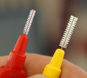 Insbesondere bei Brackets ist das gewissenhafte Reinigen von großer Bedeutung. Interdentalbürsten und Zahnseide helfen dabei.