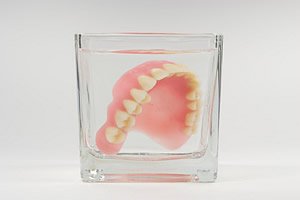 Um eine Entstehung von Pilzinfektionen bei älteren Menschen zu vermeiden, sollte der Zahnersatz regelmäßig desinfiziert werden.